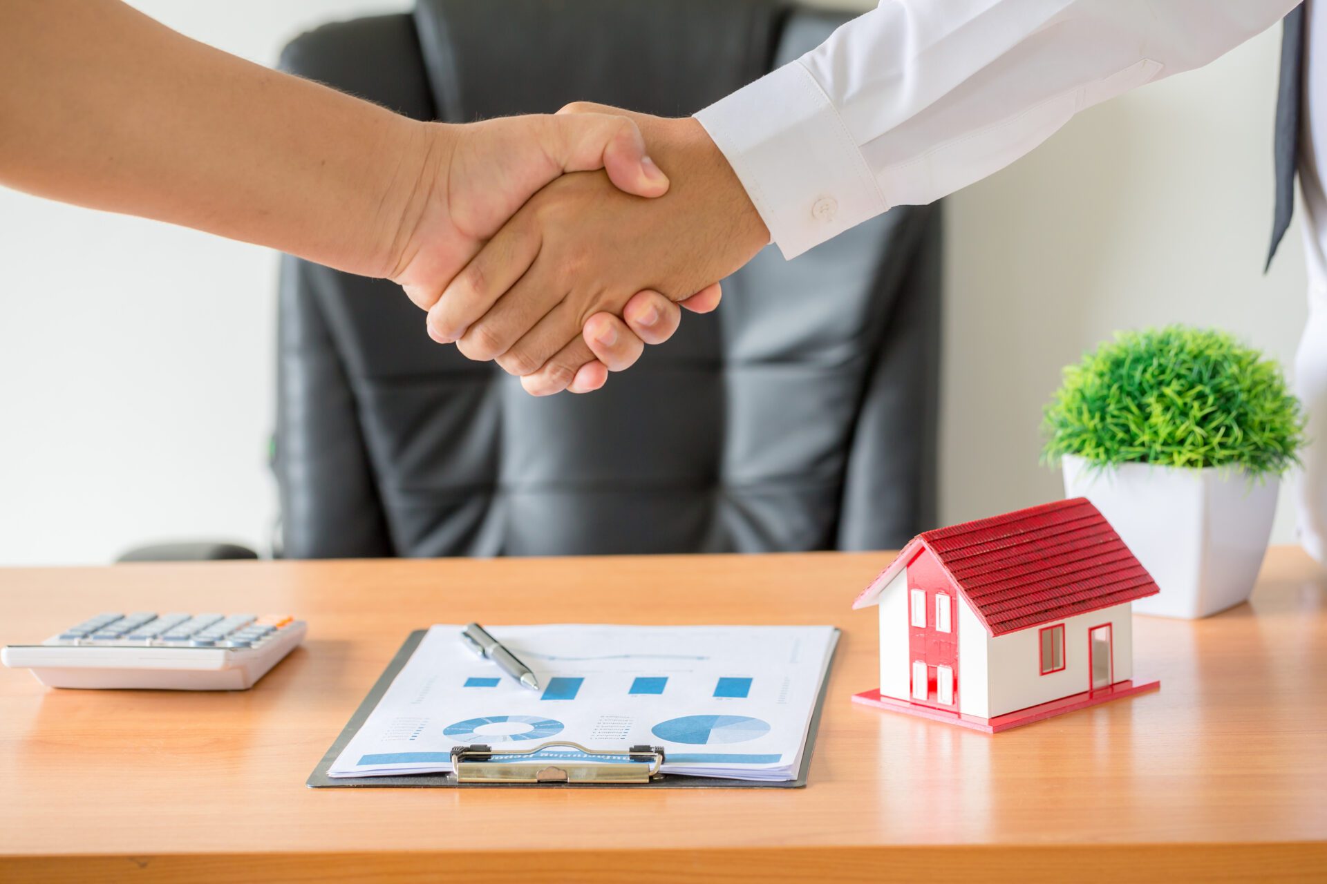 hands of agent and client shaking hands after signed contract bu Side view hands of agent and client shaking hands after signed contract buy new apartment.